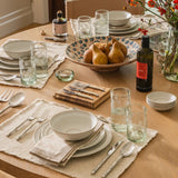 Calimia Home Biancolilla Extra Virgin Olive Oil bottle on a beautifully set wooden dining table with place settings