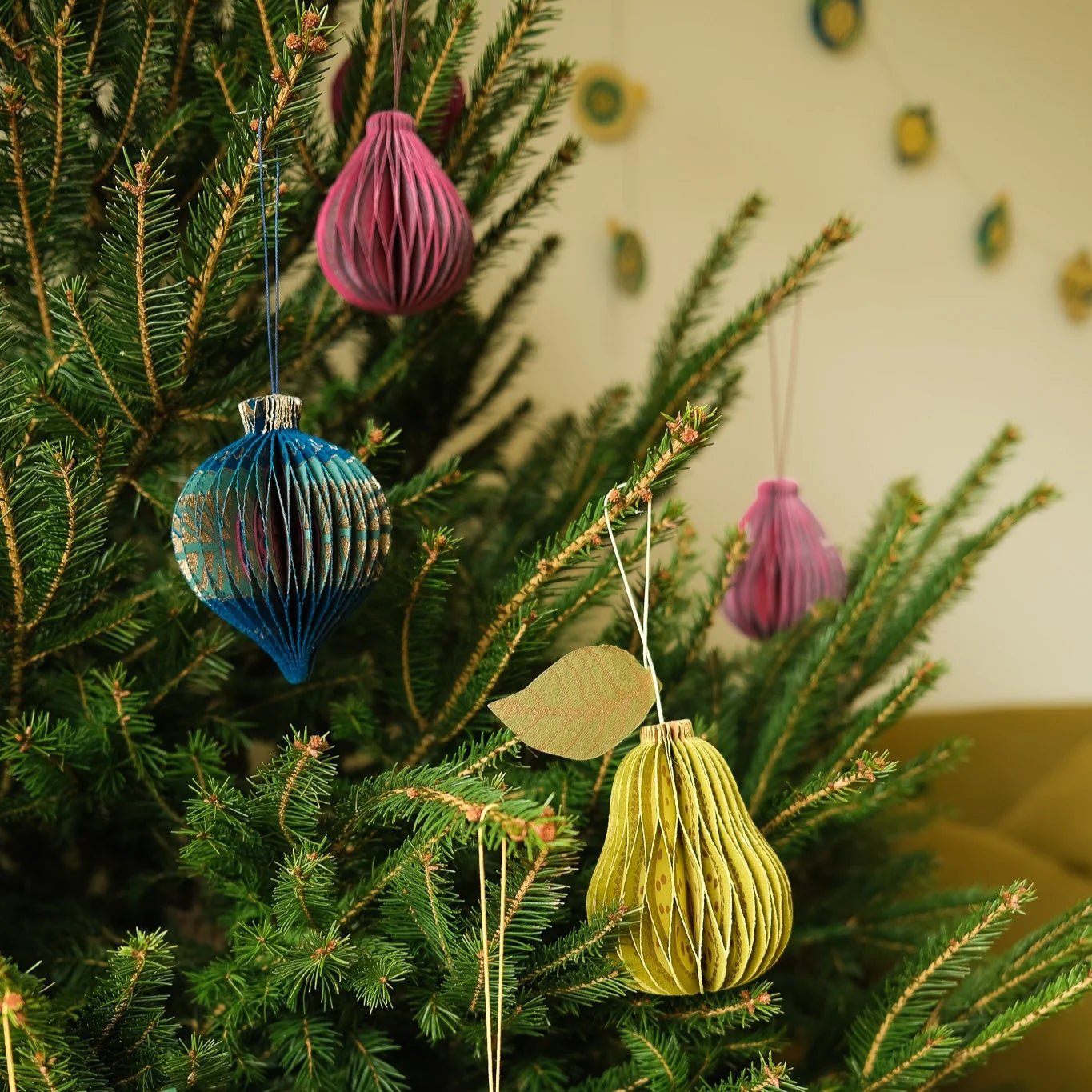 Decorative Christmas tree with colorful ornaments against a neutral background