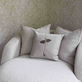 Botanical Embroidered Pillow by One Bi One — hand-embroidered plant motif on linen, styled on a boucle chair