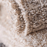 Calimia Home Brentwood throw in pebble featuring a soft multi-tonal bouclé texture and hand-loomed yarn detail.