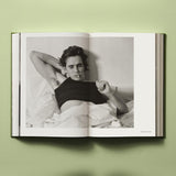 Calimia Home Bruce Weber My Education book open to a spread showing a black and white portrait of a young man in bed.