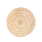 Calimia Home handwoven round Buriti palm fiber placemat in natural earthy tones with a scalloped edge.