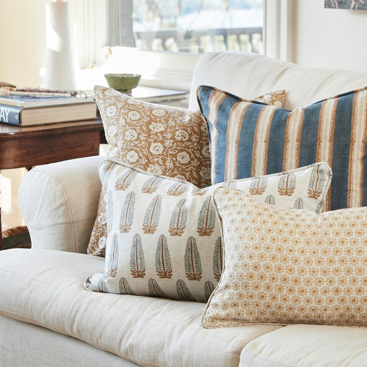 Walter G Buzios Desert pillow with feather insert, hidden zipper, and pipe edge on a white sofa