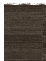 Armadillo Selva Rug in Walnut, corner close-up of the afghan wool pile and edge