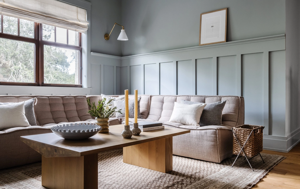 Living room with blue-gray paneled walls and a cocoa sectional in the Coral Way Craftsman project