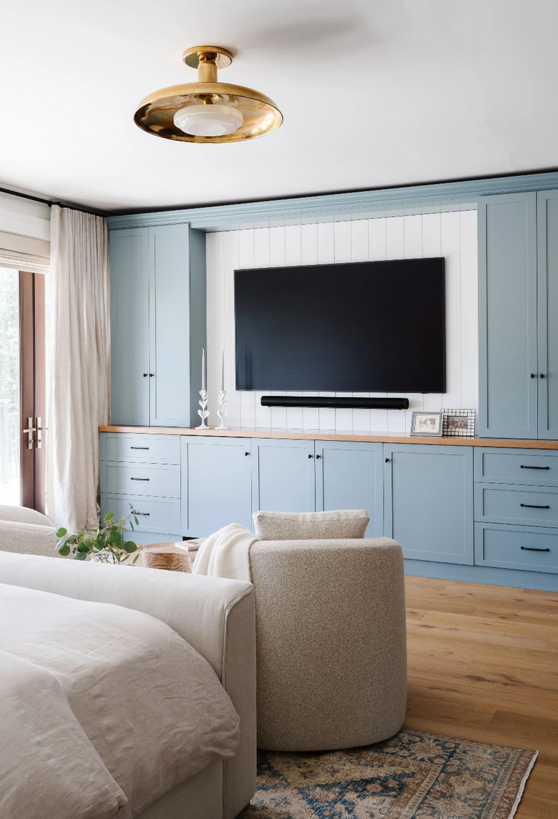 Powder-blue bedroom built-ins with wood counter and brass flushmount in the Coral Way Craftsman home