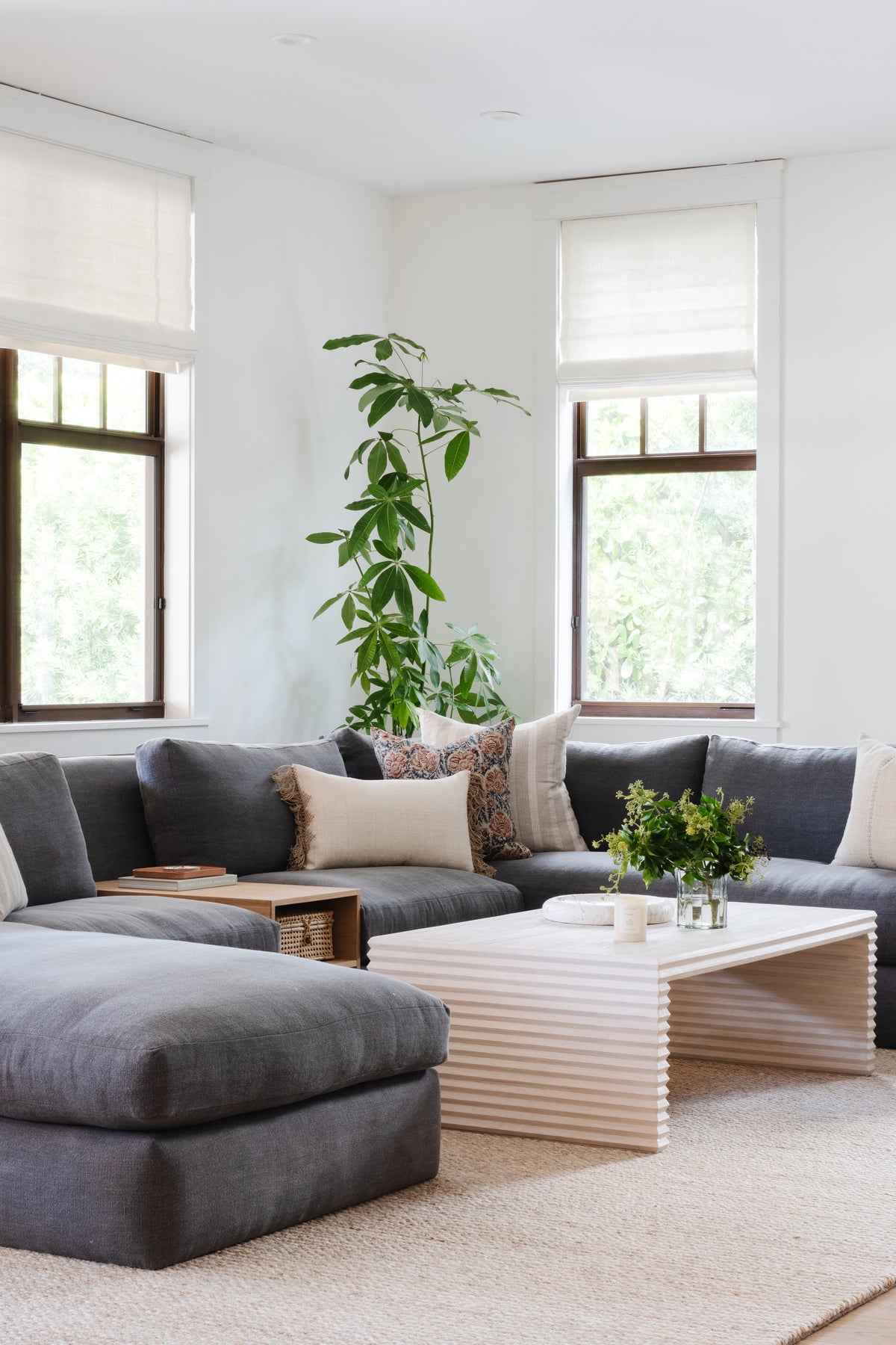 Casual sectional corner with climbing greenery and a fluted coffee table in the family room