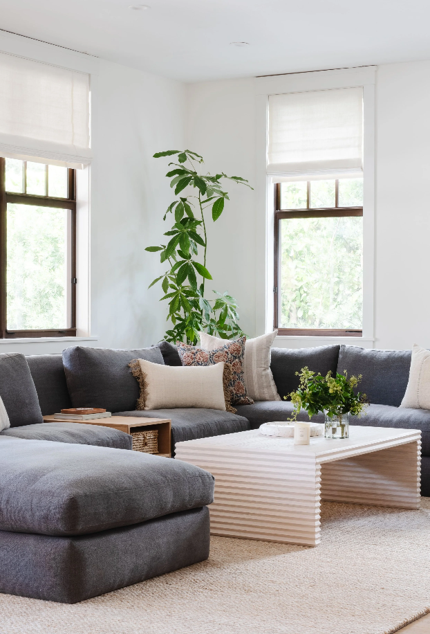 Casual sectional corner with climbing greenery and a fluted coffee table in the family room