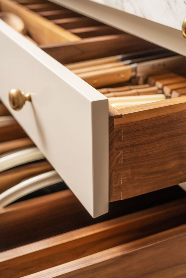 Close-up of dovetailed walnut drawer construction with brass knob, Stoffer Home Cabinetry