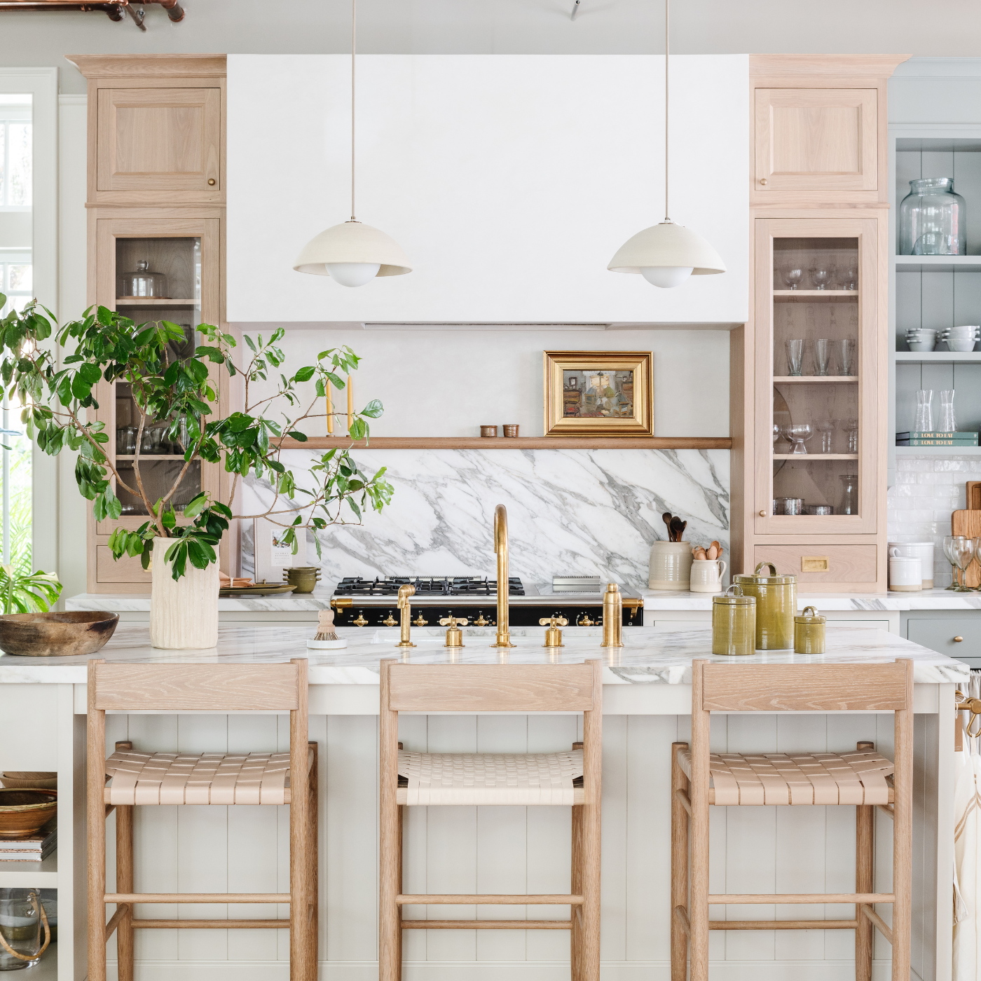 Bright custom kitchen with marble backsplash and island seating, designed by Calimia Home in Miami