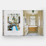 Calimia Home Everybody Loves Stripes book open to a spread showing a bathroom with a striped runner and roll-top tub.