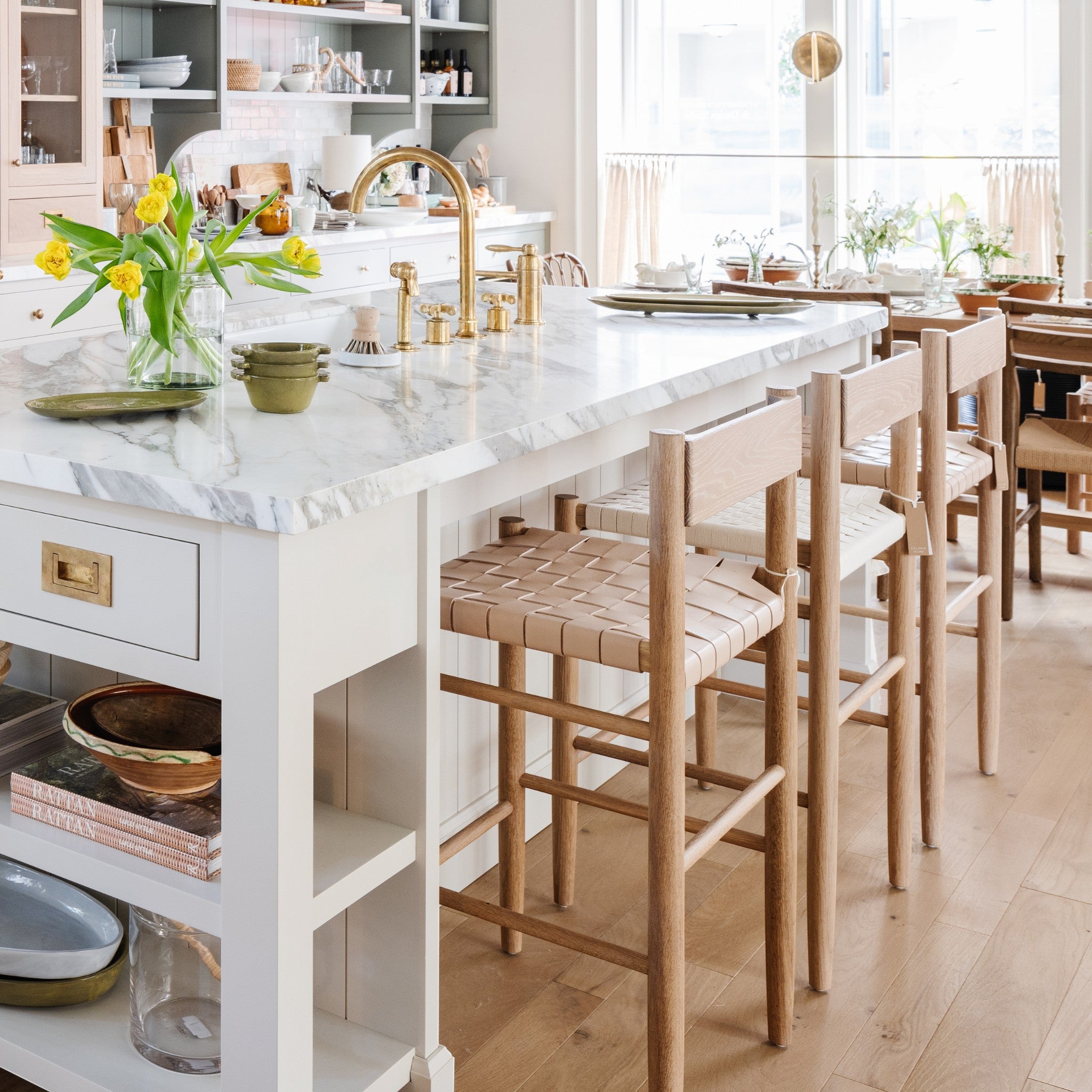 Calimia Home Gaon counter stools with solid white oak frames and woven natural leather seats in a bright kitchen.