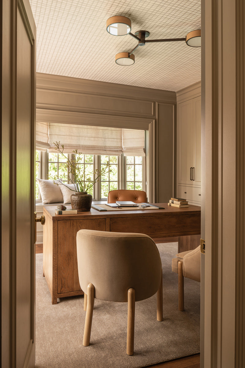 Home office seen from the doorway with an oak desk, leather chair, and textured ceiling