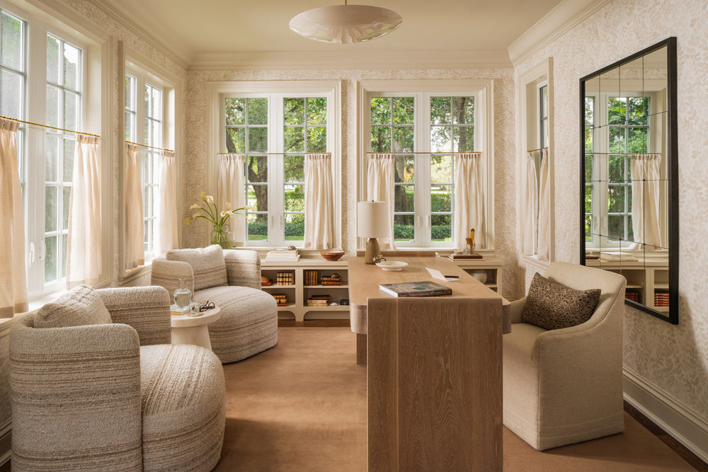 Home office with built-in cabinetry, oak desk, and a wall of windows overlooking the garden