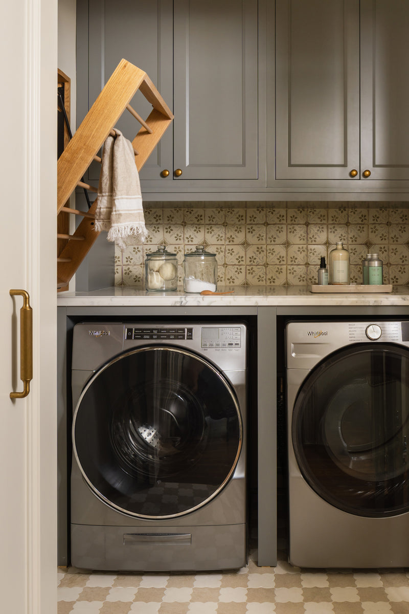 Laundry room with gray cabinets, patterned cement tile floor, and a wall-mounted drying rack