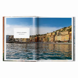 Calimia Home Great Escapes Mediterranean book open to a page showing the colorful coastal village of Punta Chiappa Italy