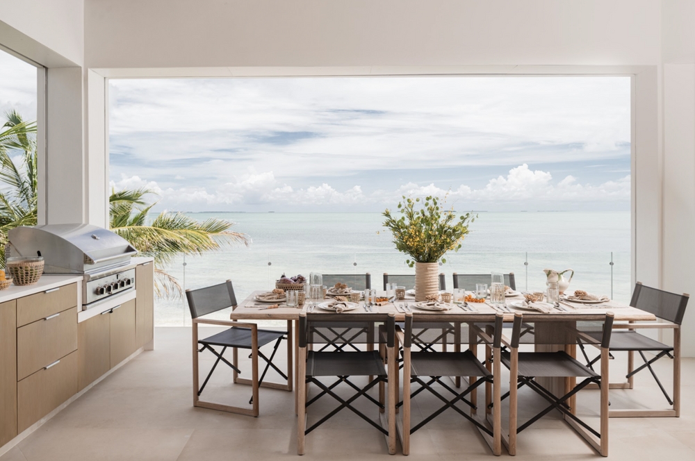 Alfresco dining table with director chairs and summer kitchen facing the Islamorada shoreline