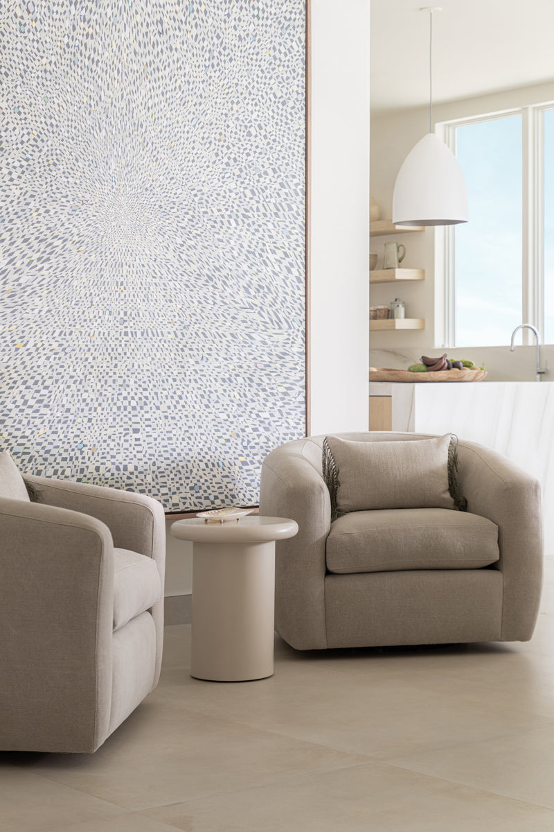 Pair of boucle swivel chairs beside a textured white canvas and sculptural side table