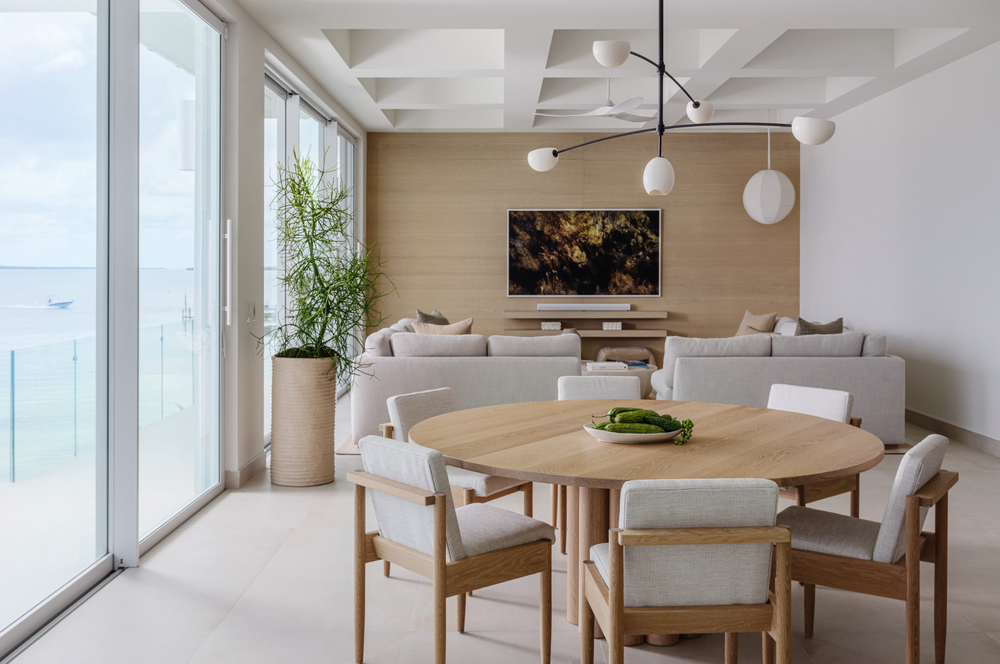 Open dining and living space with coffered ceiling and oak table in the Peaceful Waters home
