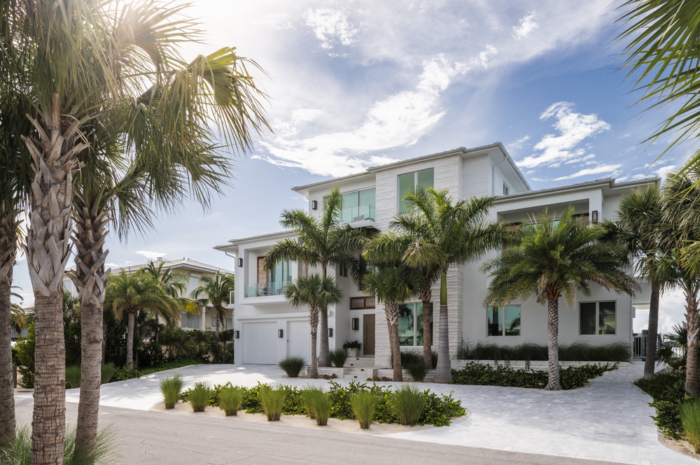 Palm-lined entry drive and coastal facade of a new-build Florida Keys home