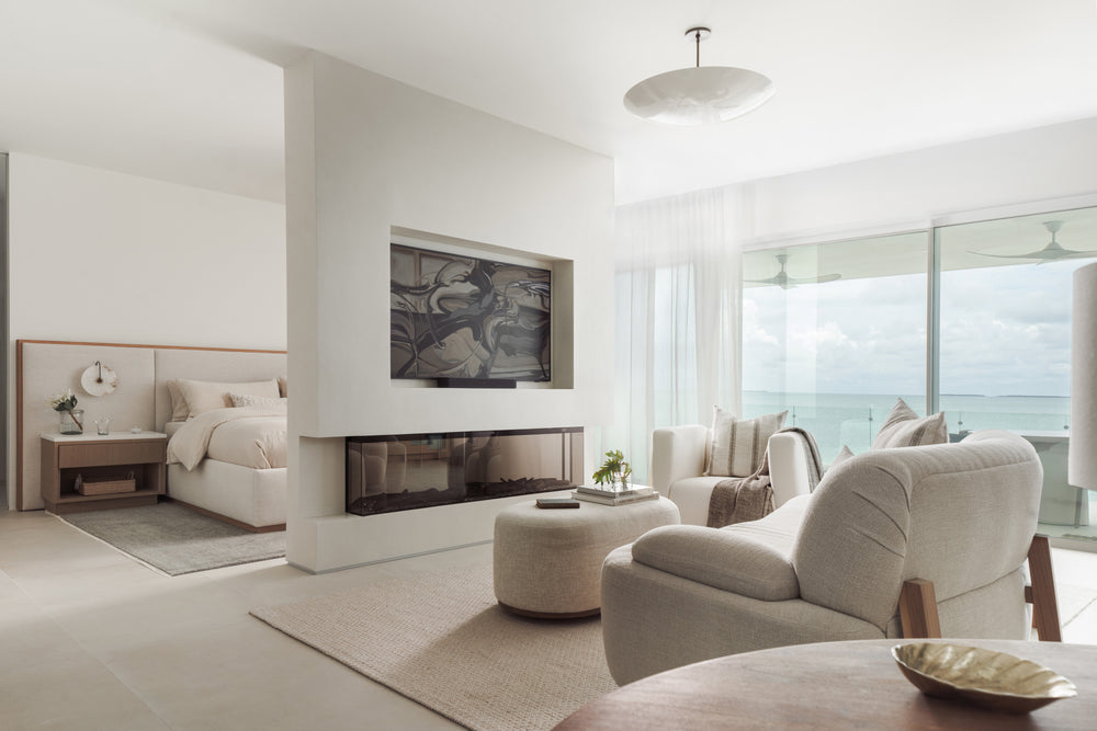 Primary bedroom sitting area with fireplace, television, and terrace access designed by Calimia Home