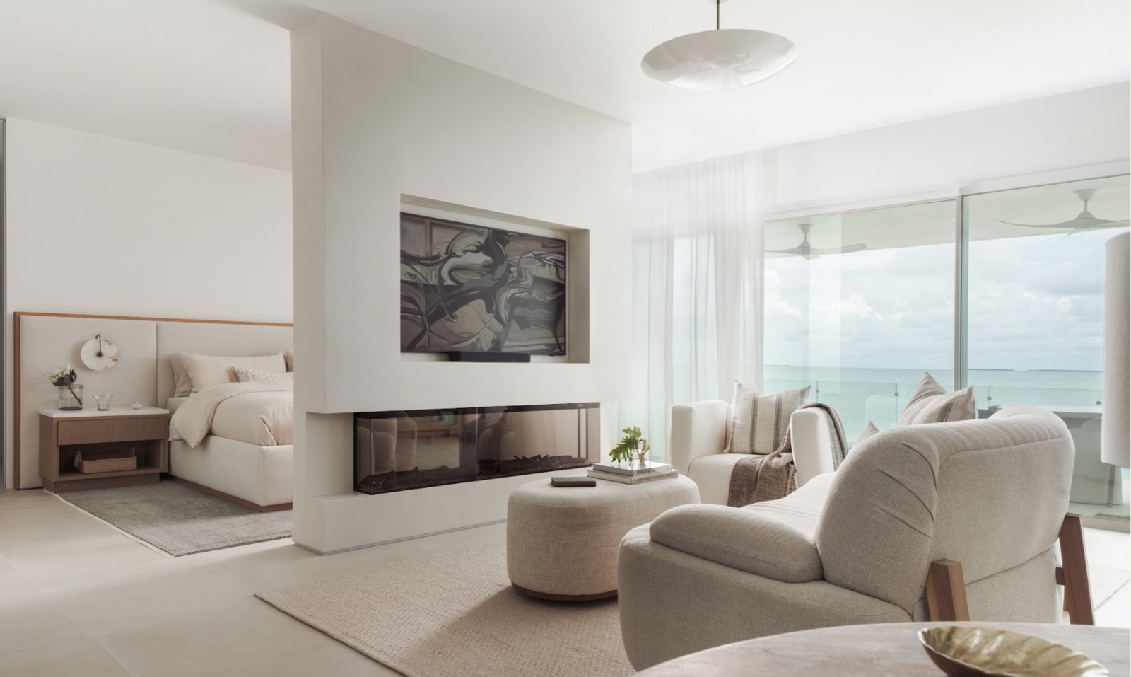 Primary suite with linear fireplace, swivel lounge chair, and sitting area opening to an ocean-view terrace