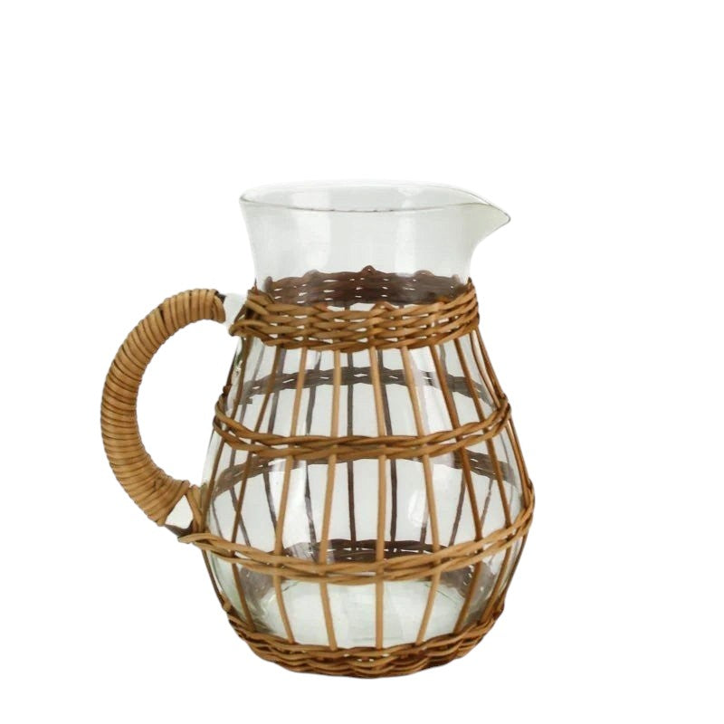 Calimia Home short glass pitcher with a decorative woven rattan cage and ergonomic rattan-wrapped handle
