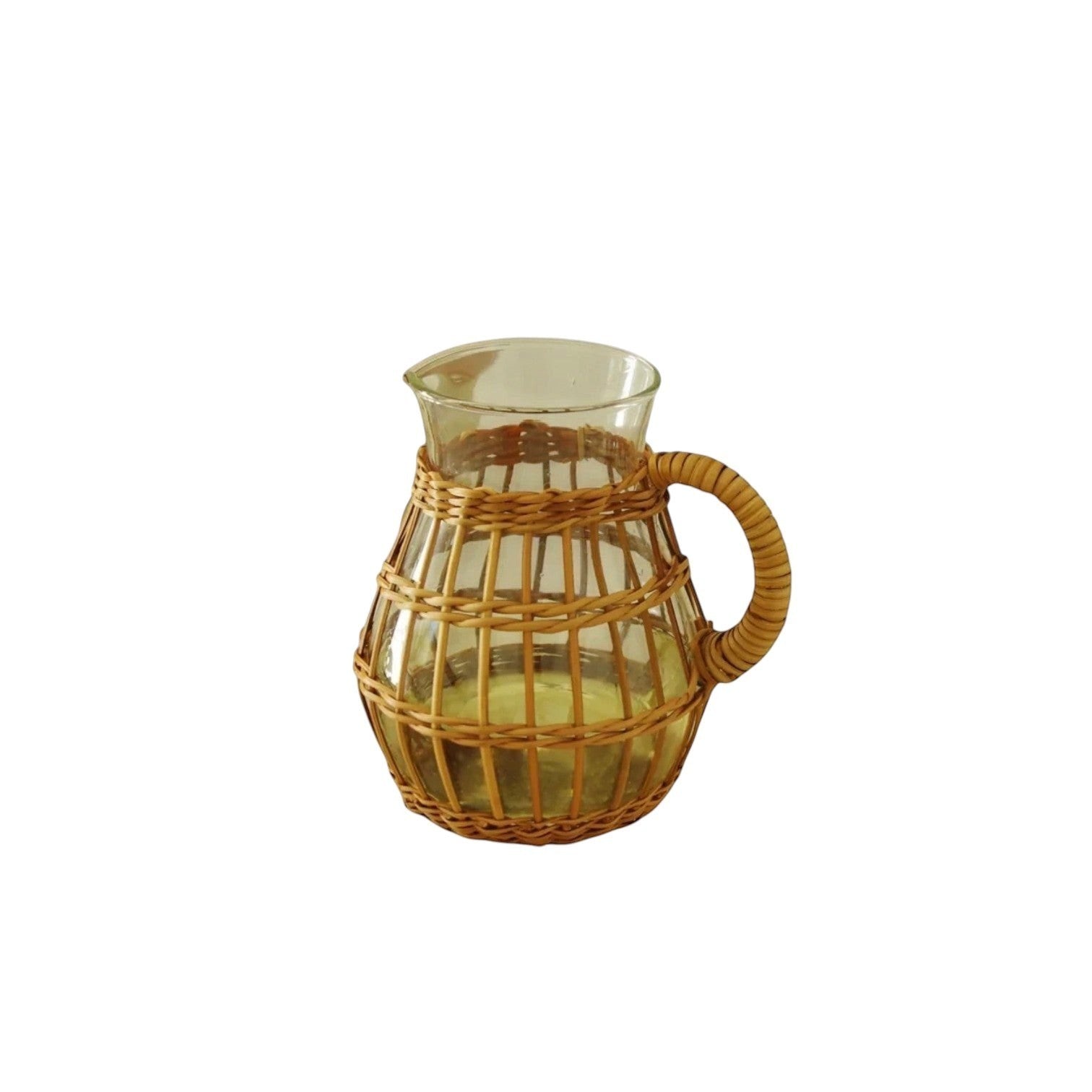 Calimia Home short glass pitcher wrapped in handwoven natural seagrass with a sturdy handle on a linen table