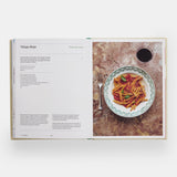 Calimia Home The Regional Italian Cookbook book open to a spread showing a regional pasta recipe on a patterned plate.