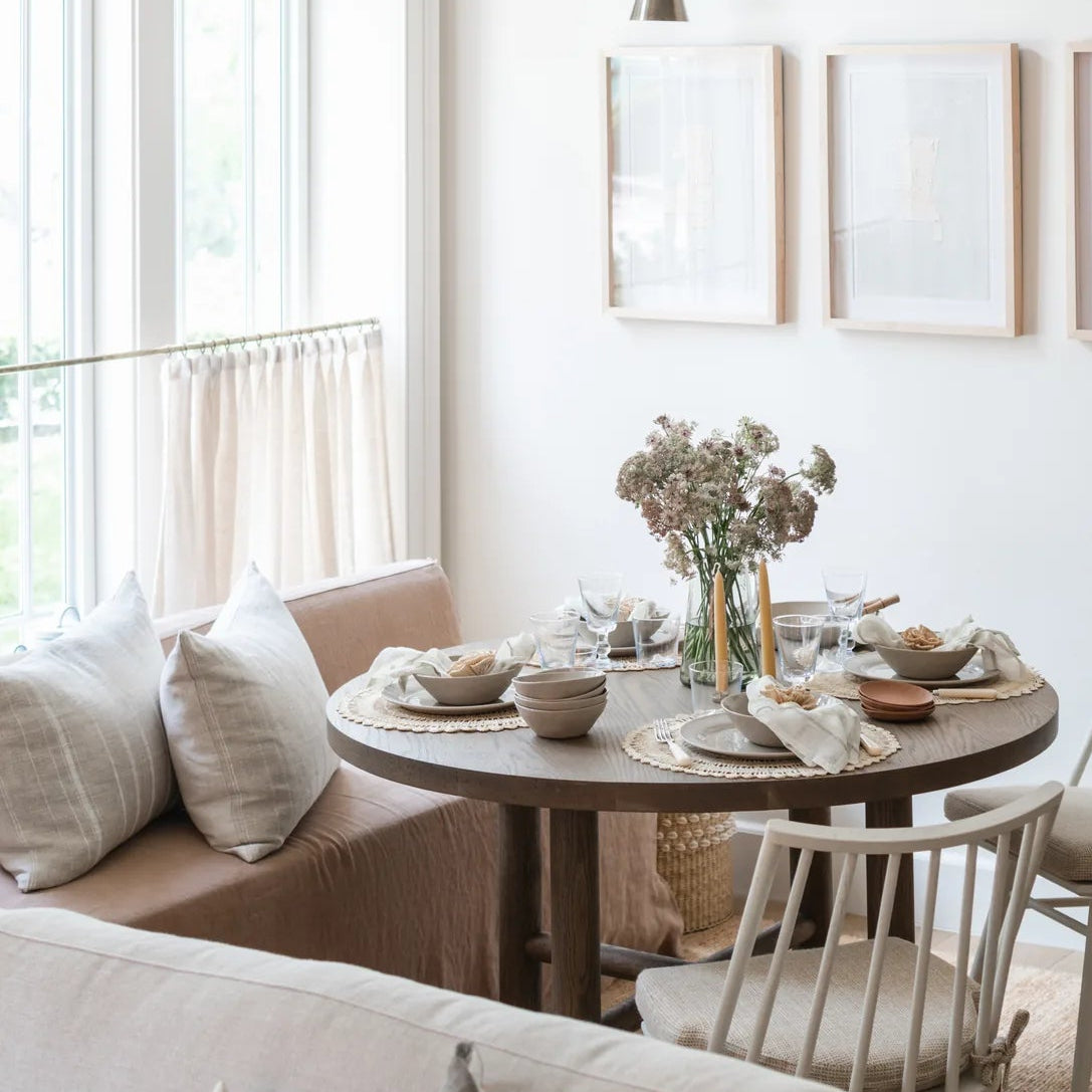 Galactic Triptych I above a dining nook with the Valencia X table, Lewis Windsor chairs and a linen sofa