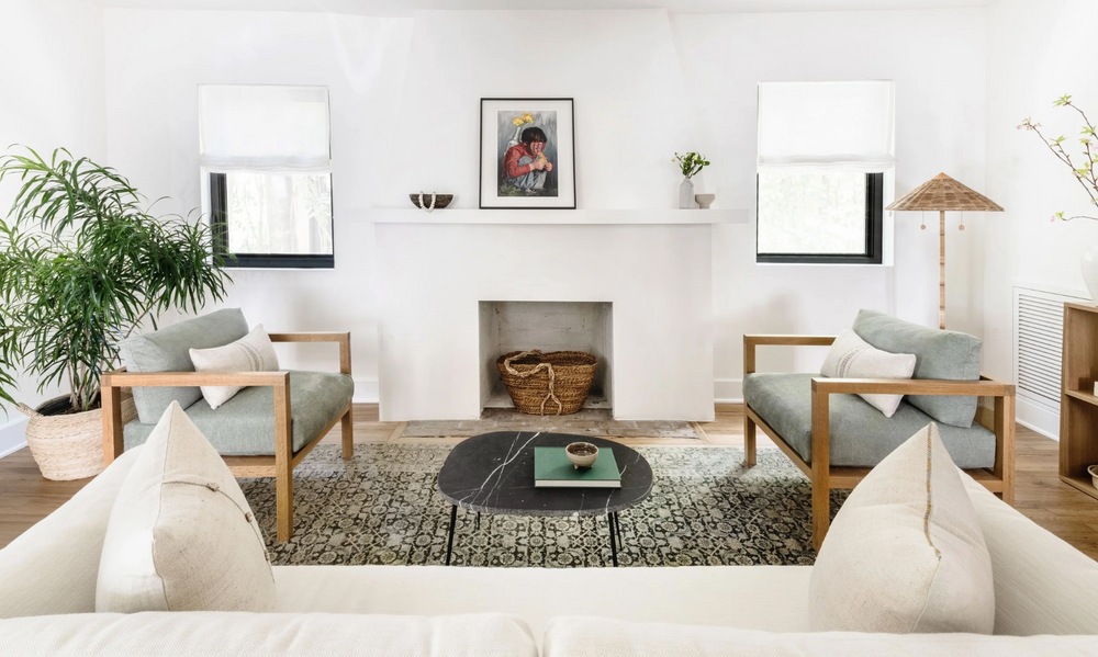 Light-filled living room with fireplace, oak armchairs, and a vintage rug in Coral Gables