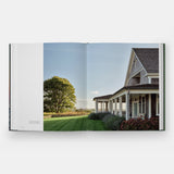 Calimia Home Summer by the Sea book open to a spread showing a shingled cottage porch facing the lawn.
