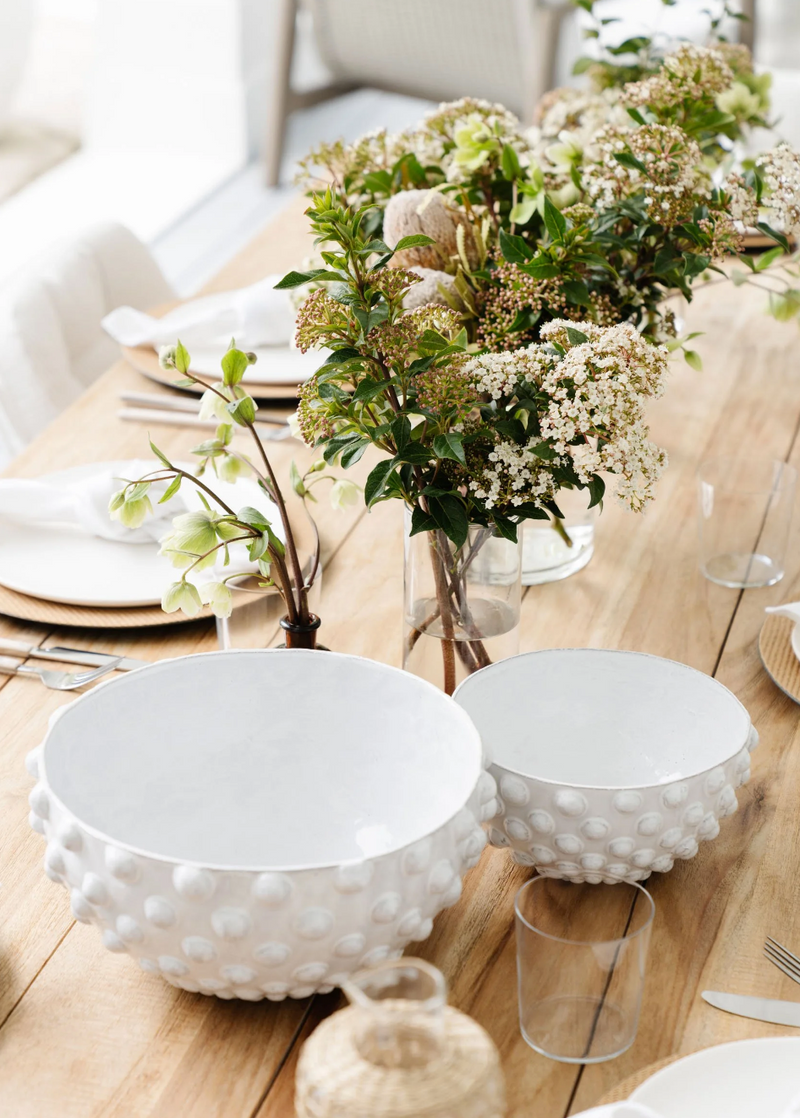 White hobnail ceramic bowls and garden greenery styled on an oak dining table