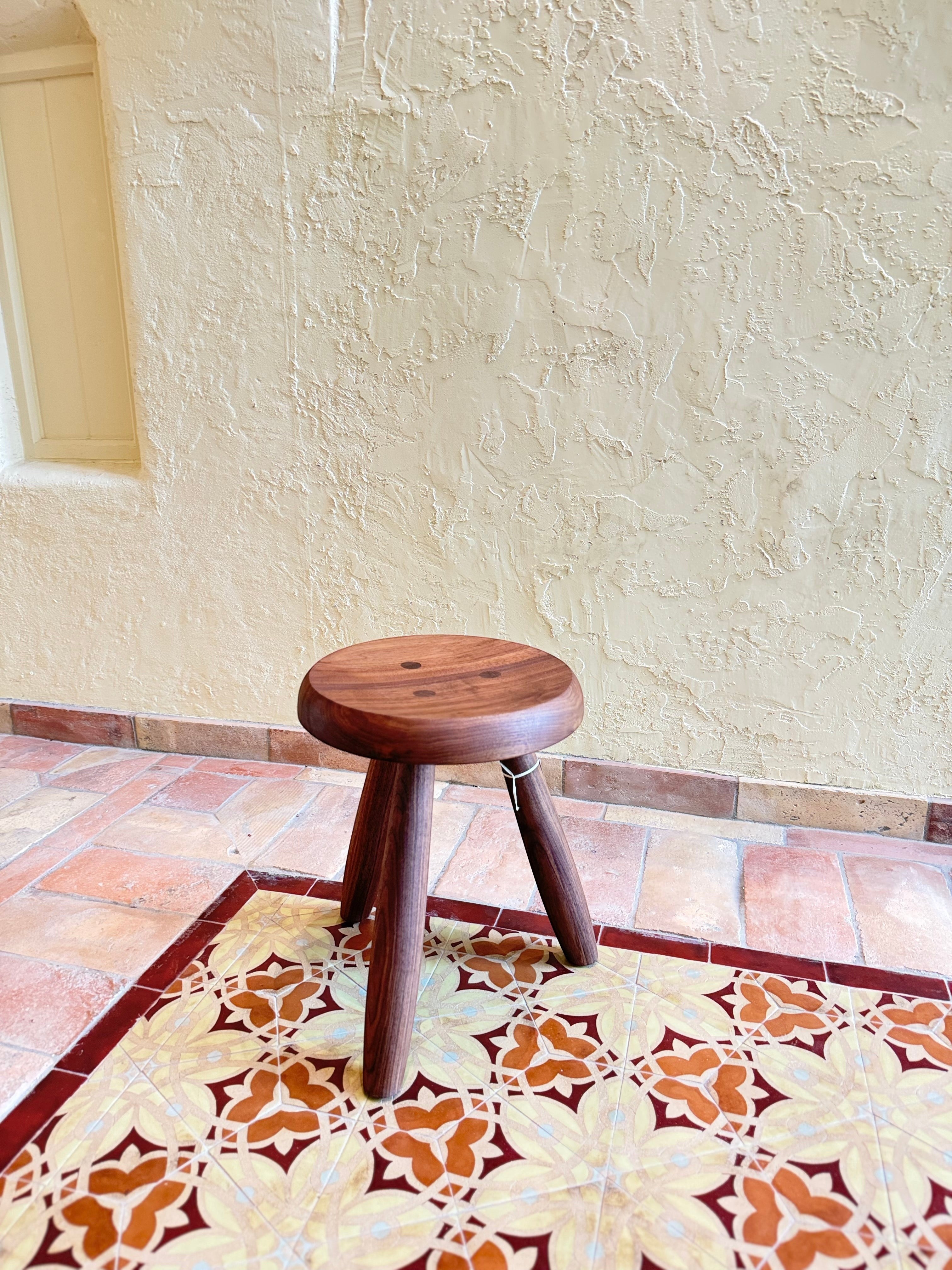 Calimia Home Tori Stool in dark wood with three tapered legs and a round top featuring traditional wedged joints.