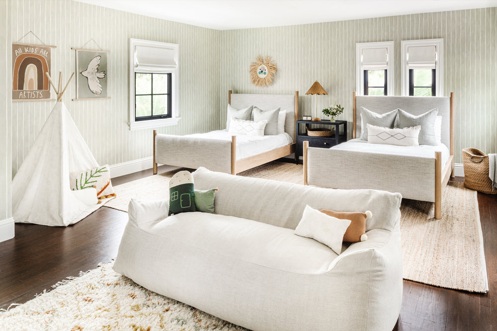 Boys' bedroom with twin beds, play tent, and plush lounger in soft neutral tones
