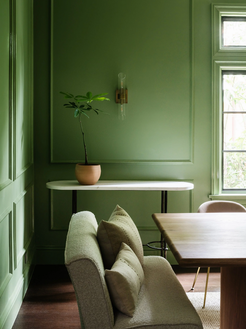 Green room with a sofa, table, and plant