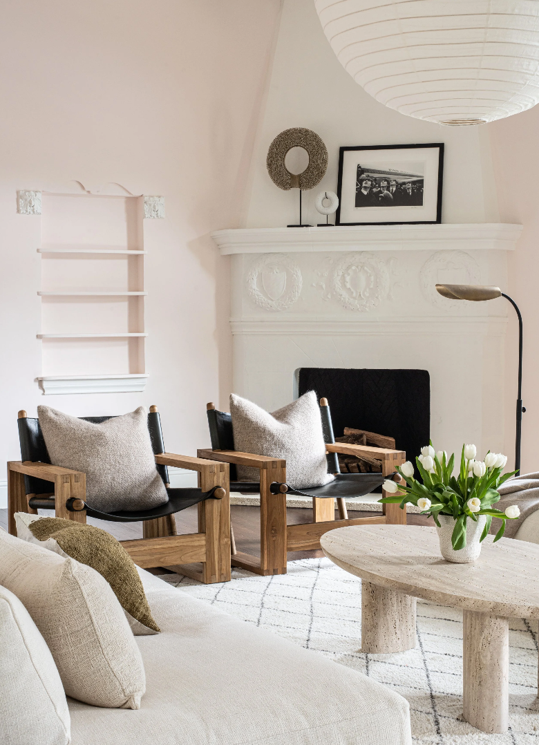Living room with wooden chairs, white sofa, and a fireplace.