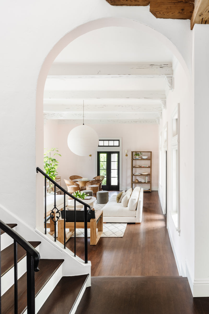 Arched stair landing opening to the beamed living room of Villa Belmonte in West Palm Beach