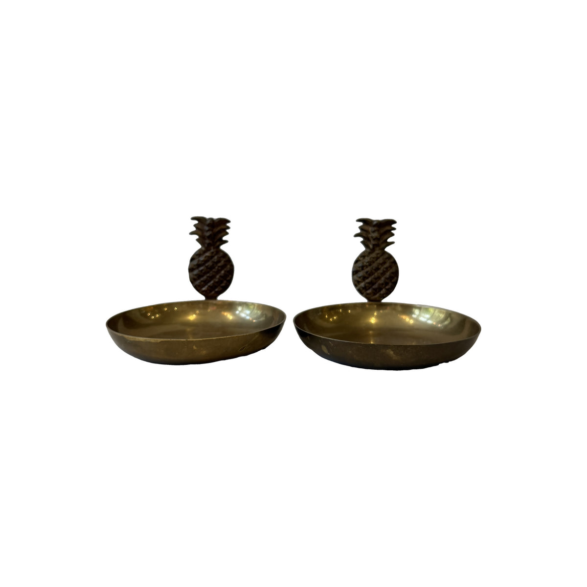 Pair of vintage brass pineapple dishes in profile, each with a cast crosshatched pineapple finial rising from the rim