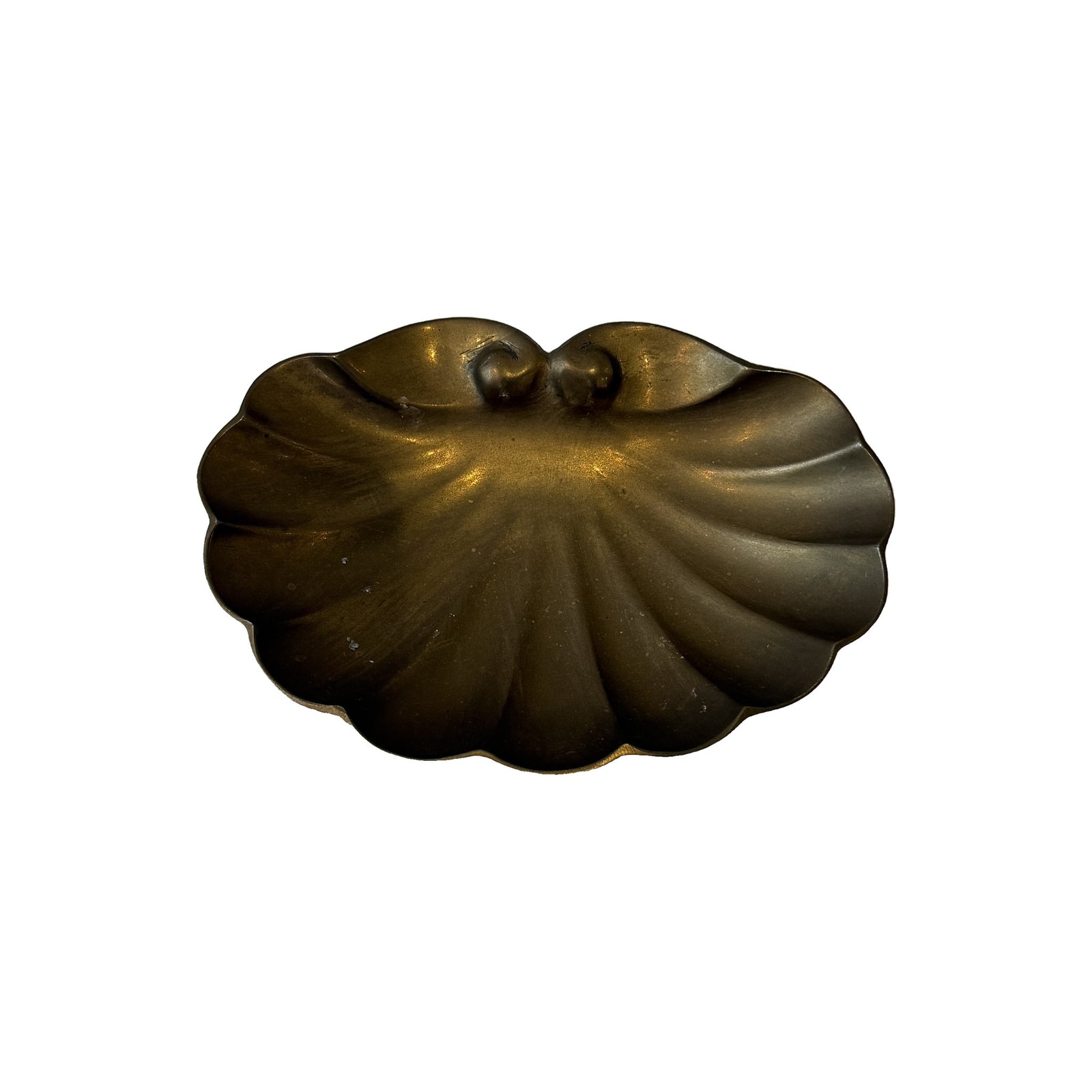 Vintage brass scallop shell dish seen from above, cast fan of ribs radiating from scrolled hinge volutes with darkened patina