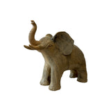 Carved wood elephant front three-quarter view showing separately cut ears, tusks and broad tool marks across the hide