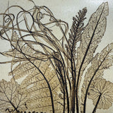 Close-up of a vintage ceramic botanical wall tile showing the deep relief texture of fern and dock leaf impressions