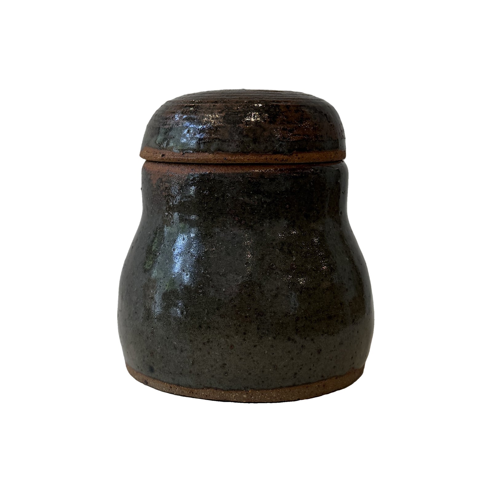 Studio pottery lidded jar in mottled near-black glaze with domed lid and bands of bare reddish clay at the foot and rim