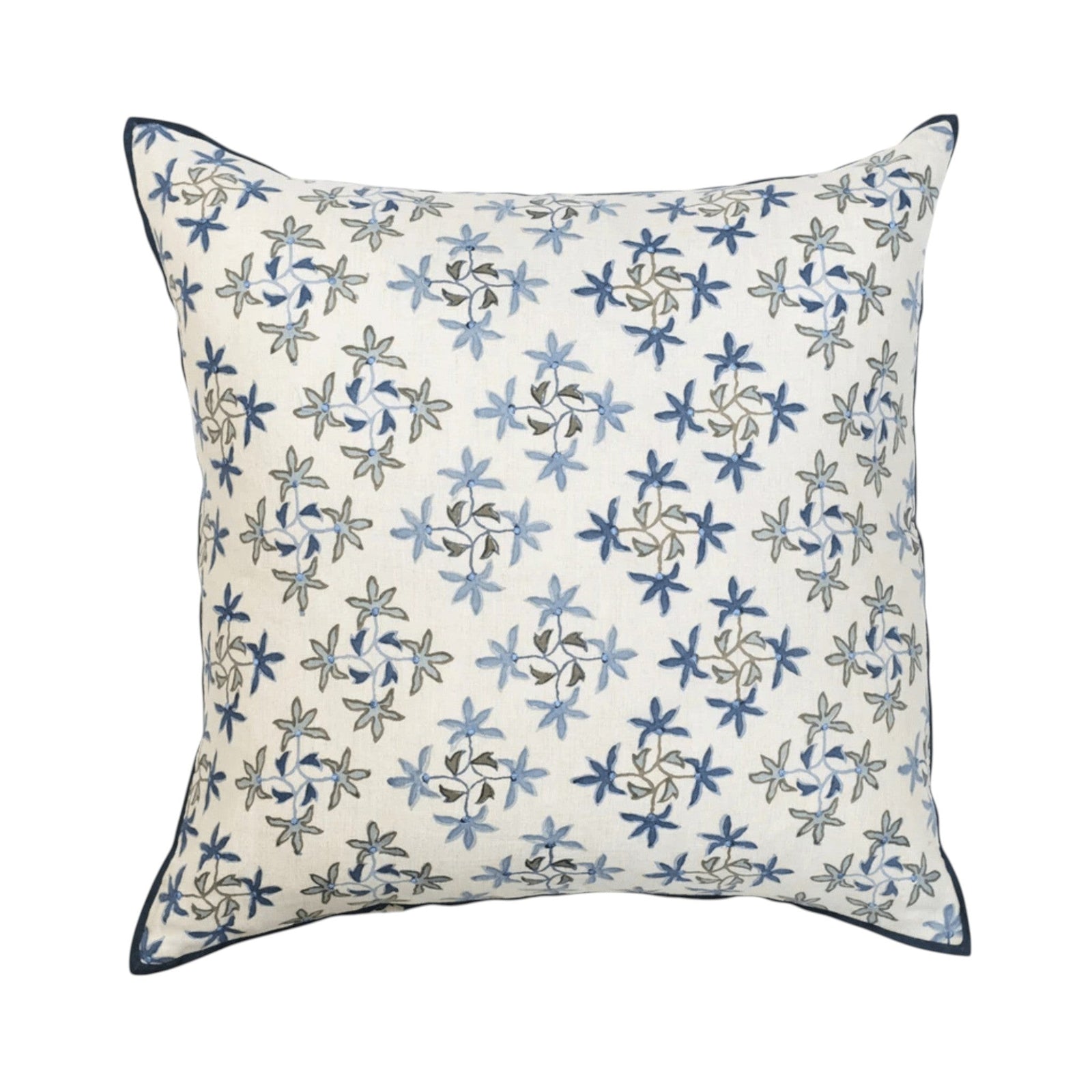 Maison Venu Celeste Lapis pillow with blue floral embroidery on a white background and dark blue piped edges.