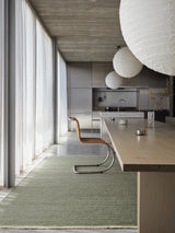 Armadillo Cable Rug in Jade, handwoven soumak wool rug shown in a room setting