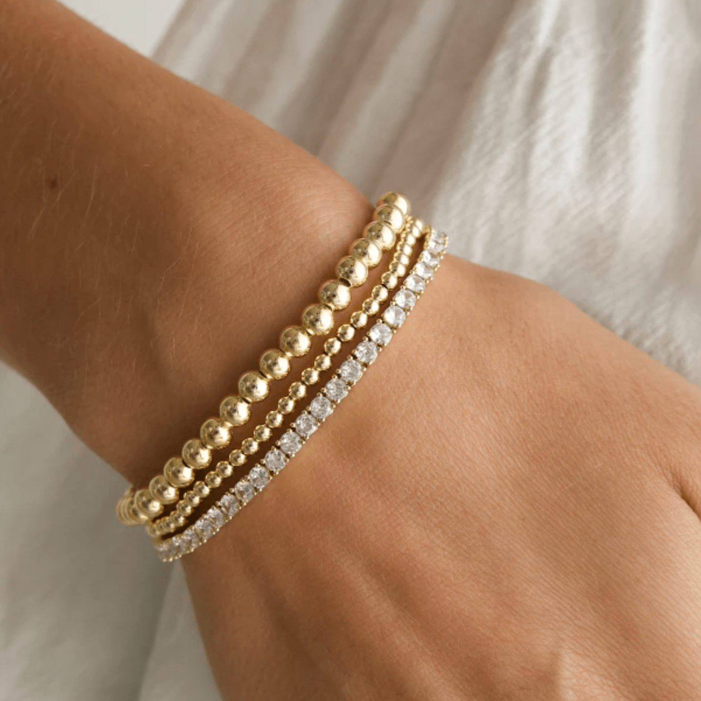Stacked crystal tennis bracelets in yellow gold