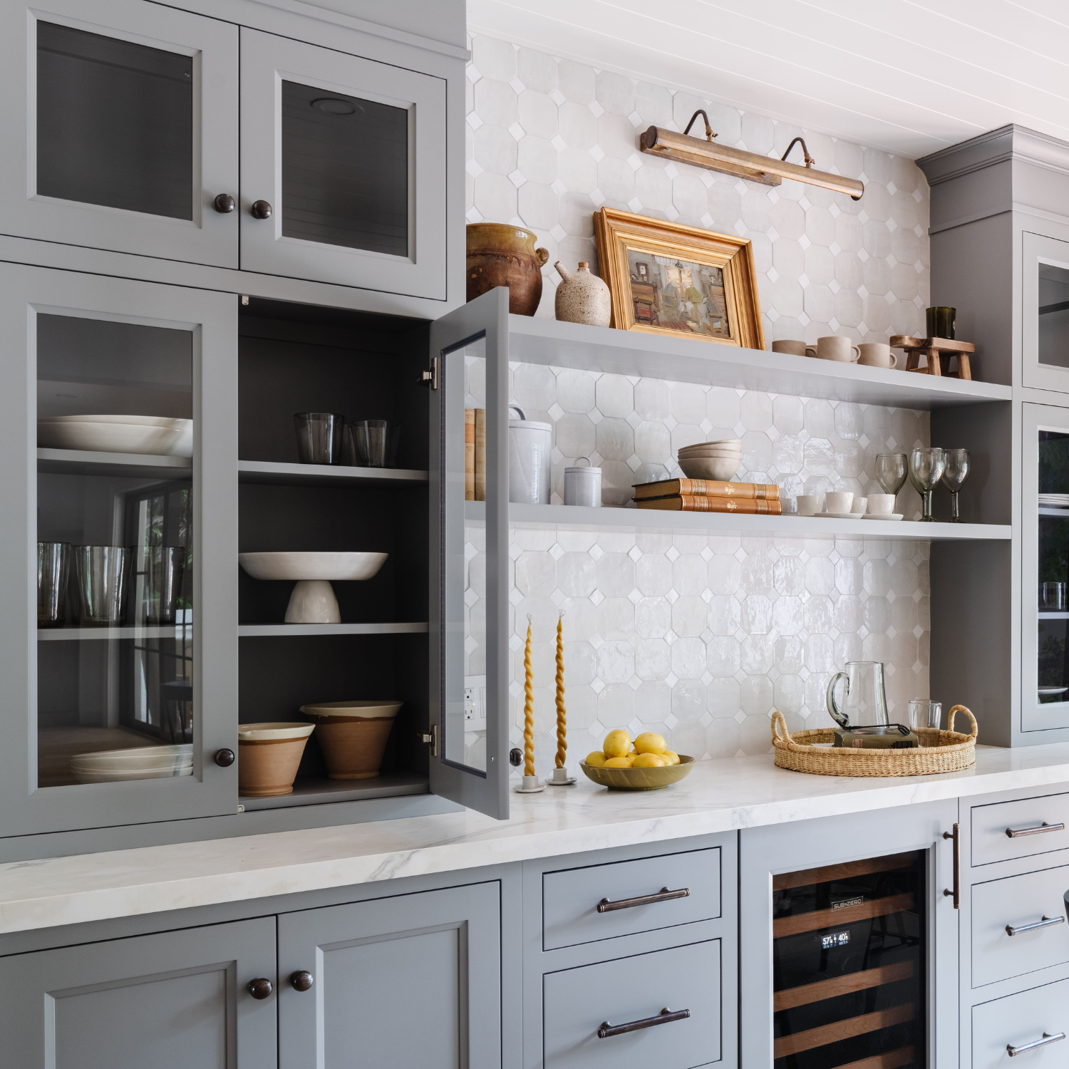 Custom shaker cabinetry with glass-front doors, marble countertops, and styled open shelving designed by Calimia Home, luxury interior designer in Miami