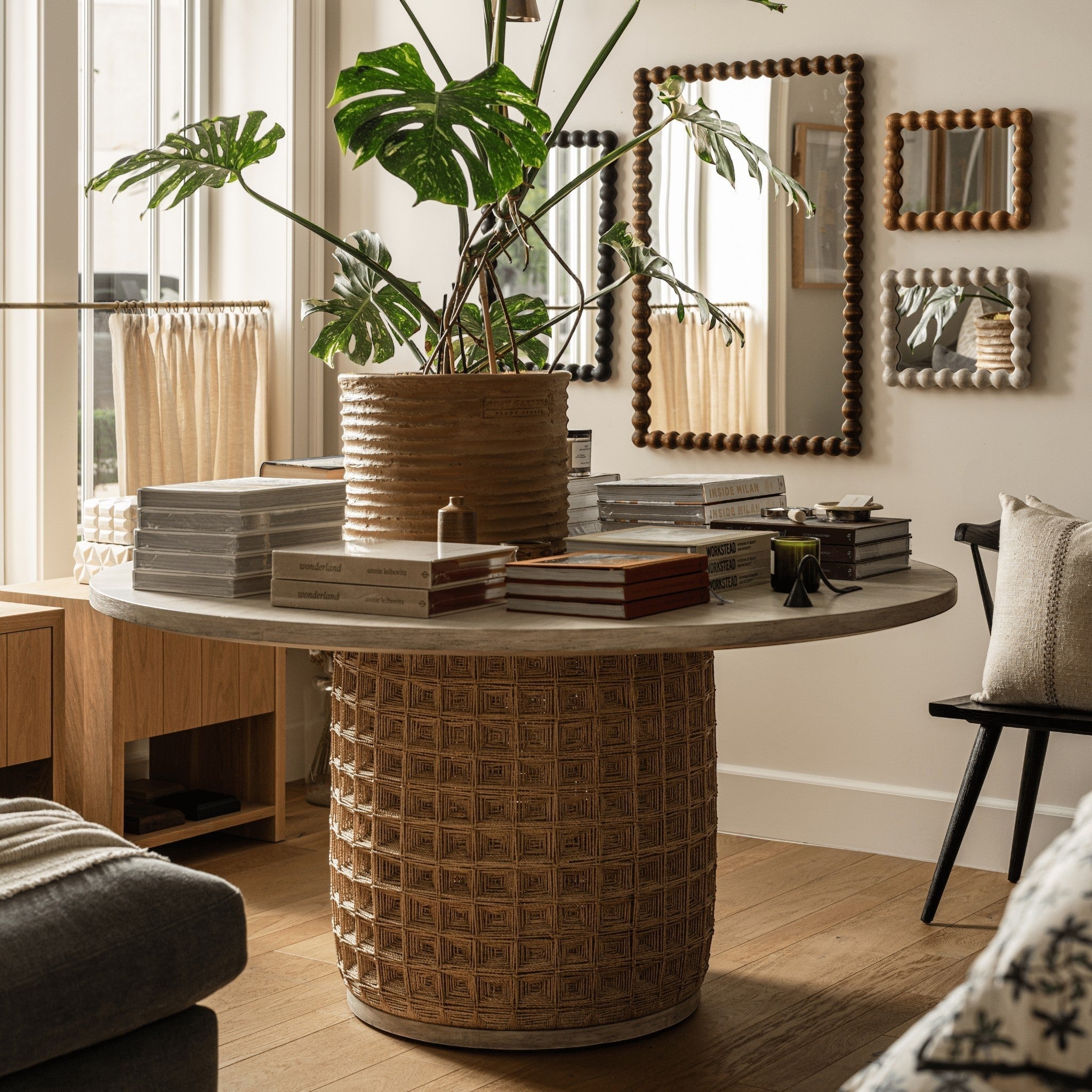 Calimia Home Damien round dining table with a white-washed hardwood top and a hand-woven abaca rope square pattern base.