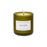 An olive-green glass candle jar with a pale seafoam label reads Flamingo Estate, Douglas Fir & Ancient Vetiver, hand-poured scented candle, 8 oz, 226 g. The lit candle sits on a white background.