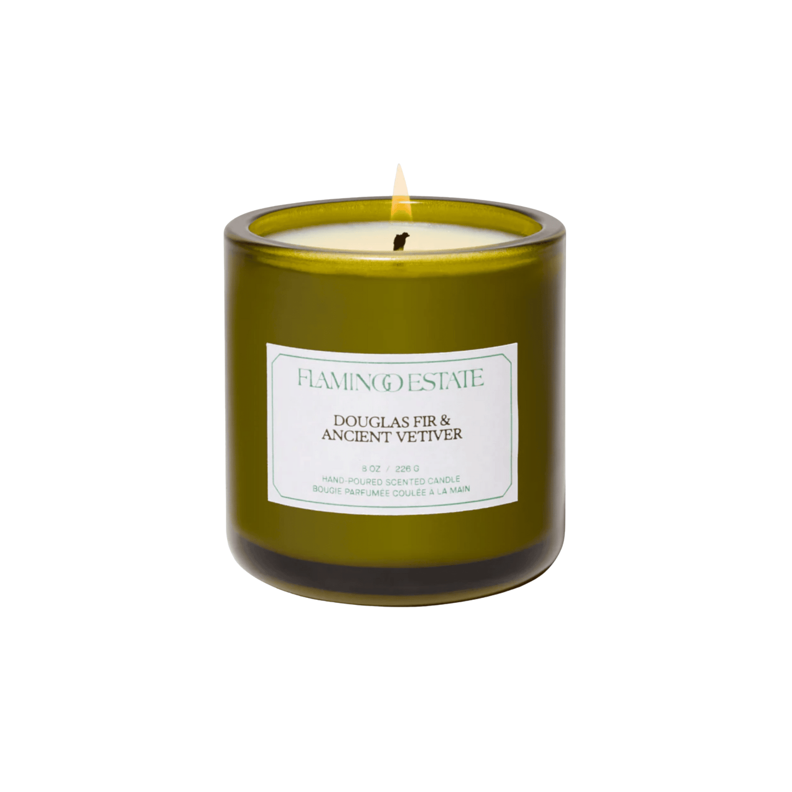 An olive-green glass candle jar with a pale seafoam label reads Flamingo Estate, Douglas Fir & Ancient Vetiver, hand-poured scented candle, 8 oz, 226 g. The lit candle sits on a white background.